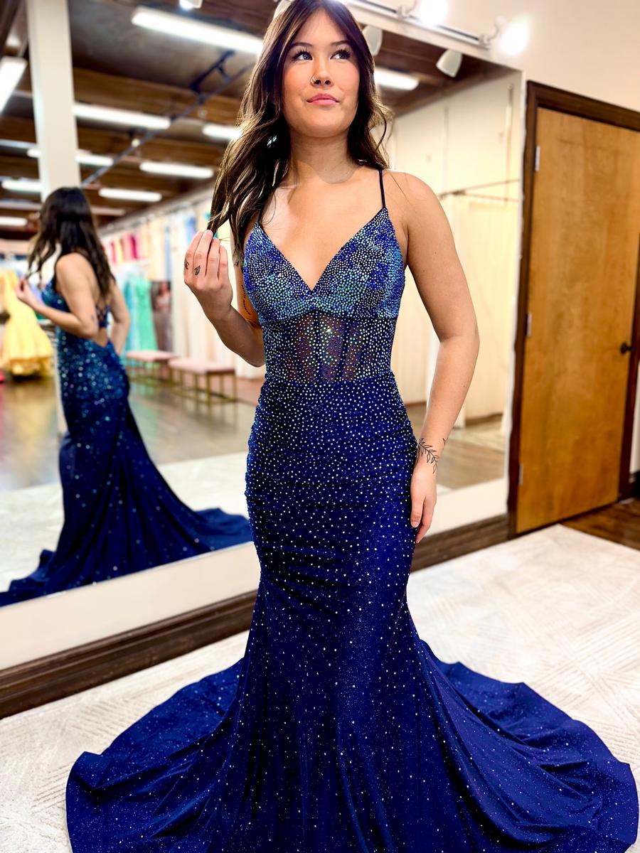 Prom dress features crystals in shades of blue on a shimmer glitter navy jersey fabric and sheer mid bodice with exposed boning